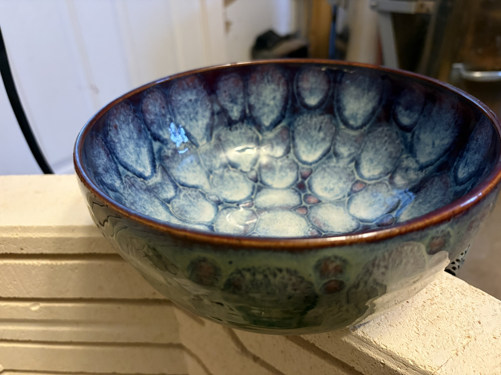 A handmade bowl with blue and cream glaze patterns