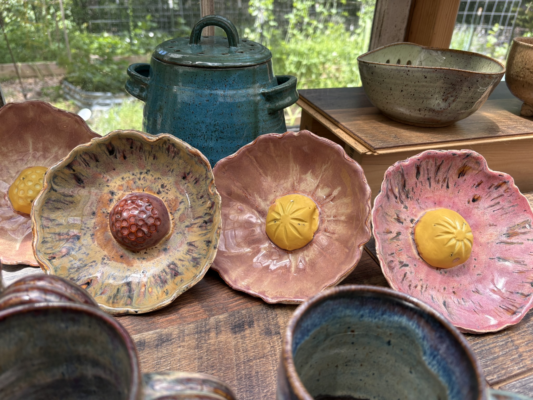 Flower-shaped pottery plates in warm pink and yellow glazes