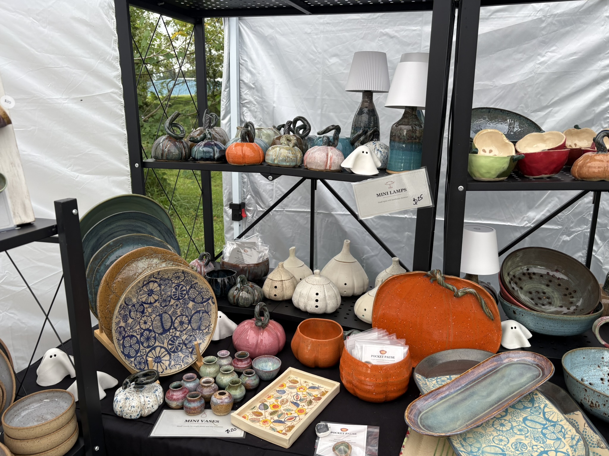 A pottery display of serving platters, pumpkins, small vessels, and bowls