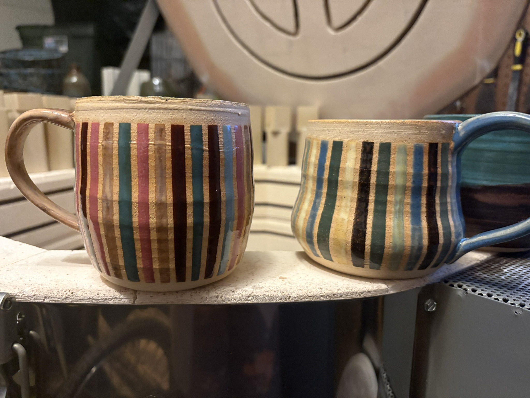 Two handmade mugs with multicolored vertical stripes