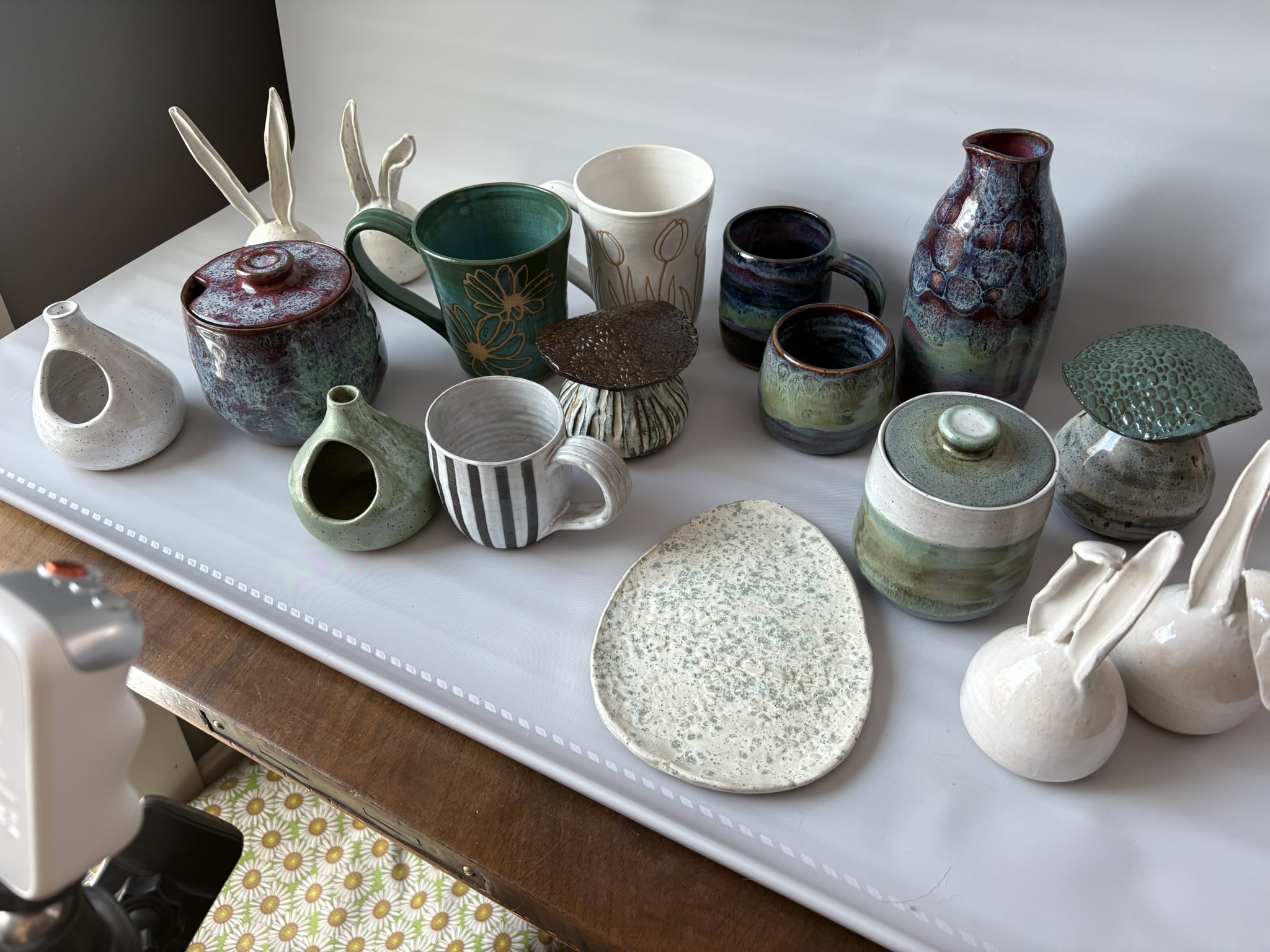 Handmade vases, mugs, lidded jars, and small dishes displayed together